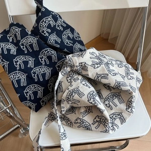 Detailed macro view of embroidered sheep patterns on vintage canvas tote bags textures
