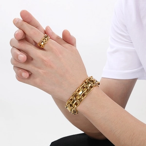 Golden X-link stainless steel bracelet and ring set worn by model on white background