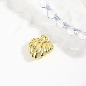 Detailed view of a gold-plated shell pendant with textured finish on marble surface