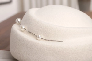 Détails du chapeau en feutre de laine blanc cassé avec perles et chaîne en strass chic