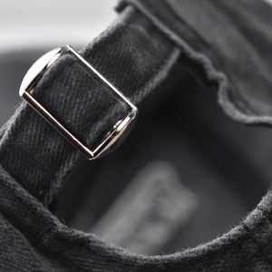 Detail of adjustable metal buckle and washed cotton texture on vintage baseball cap