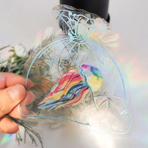 Close-up of transparent PVC gift bag featuring a colorful watercolor jellyfish illustration