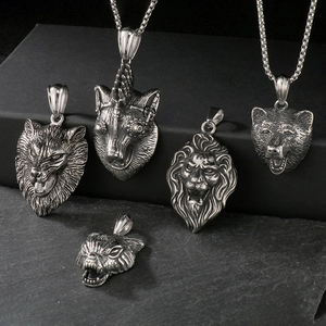 Detailed view of silver wolf and lion head pendants with antique punk metal finish
