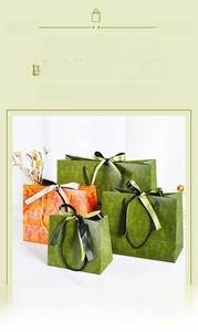 Detailed view of damask pattern paper gift bags with silk bow and various sizes