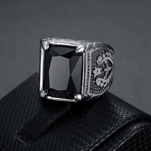 Detail of vintage silver ring with black square gemstone and side relief carving