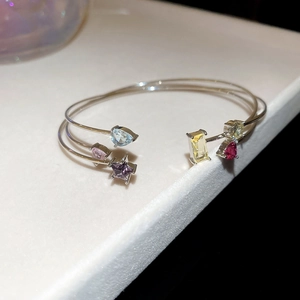 Close-up of double-layer silver open bangle with colorful zircon stones on display