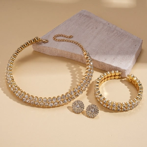 Close-up of luxury gold-plated rhinestone jewelry set featuring necklace, bracelet, and studs