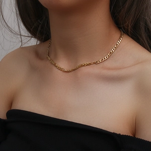Dettaglio della collana a catena Figaro dorata su una modella con finitura lucida