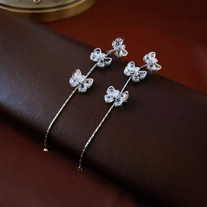 Detail of silver long tassel earrings with sparkling cubic zirconia butterfly charms