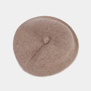 Dettaglio del berretto in maglia cammello e grigio con trama spessa e design a punta