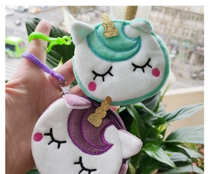 Details von grünen und lila Einhorn-Plüschgeldbörsen mit farblich passenden Haken