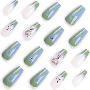 Blue and green plaid press-on nails with silver cross and heart charms on white background