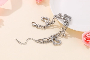 Gros plan d'un bracelet multicouche en acier inoxydable avec des pendentifs en cœur