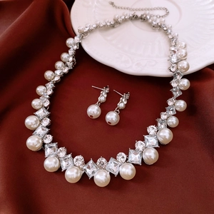 Exquisite pearl and rhinestone jewelry set detail on elegant vintage red fabric