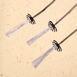 Spider cat wand toy with silver tassels and colorful beads on a textured background