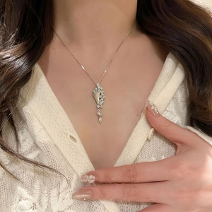 Close-up of elegant hourglass pendant necklace with shimmering zircon inlay on model