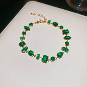 Detailed macro view of 18K gold plated flower bracelet with emerald green zircon stones