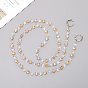 Detail of beaded heart chain with transparent and gold beads and metal ring clasps