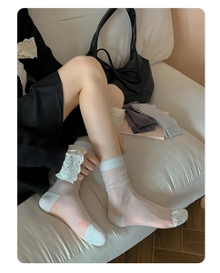 Detail of sheer light blue striped mid-calf socks shown on a model in a cozy setting