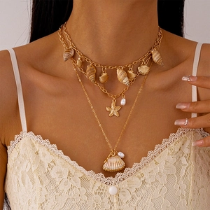 Multilayer gold ocean necklace featuring starfish, shell pendants, and pearls for beach vacation
