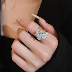 Detail view of gold wide band ring featuring clustered white pearls and micro-beads