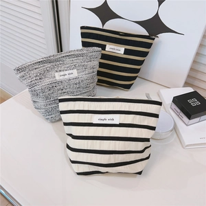 Detailed shot of striped and tweed fabric makeup bags with simple wish labels