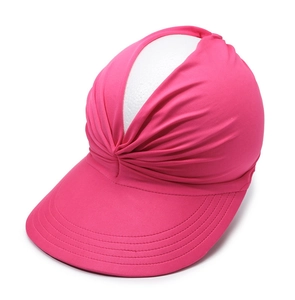 Detail view of rose red sun visor with elegant pleated fabric design on white background