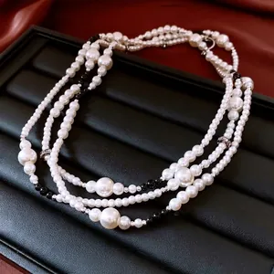 Collier de perles vintage français multicouche avec perles noires sur velours sombre