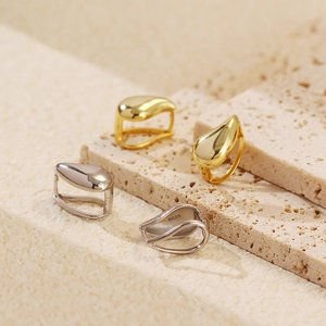 Macro shot of minimalist S925 sterling silver water drop earrings in gold and silver finish