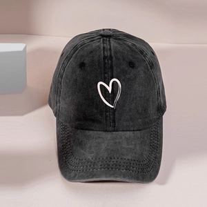Classic washed black baseball cap featuring a white heart embroidery in a retro streetwear style