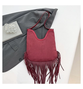 Flat lay detail of red bohemian fringe shoulder bag made of soft faux suede texture
