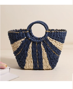 Close-up of woven straw tote bag featuring blue and gold thread striped texture