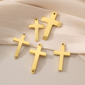 Polished 18K gold plated titanium steel cross pendants on silk background