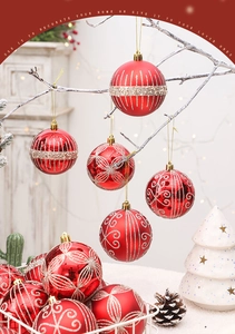 Détail de boules de Noël rouges avec motifs pailletés sur des branches festives blanches