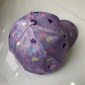 Top view of a purple kids' baseball cap featuring colorful all-over heart pattern