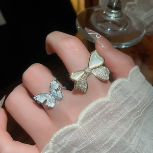 Close-up of 14k gold plated butterfly and floral ring with zircon and pearl shell