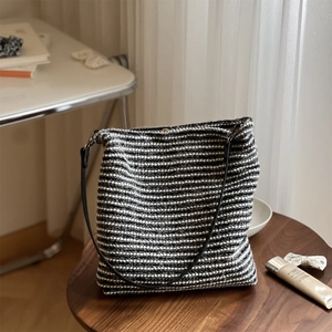 Détail du sac cabas rayé noir et blanc avec bandoulière en cuir et texture tissée
