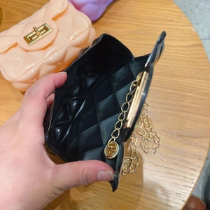 Vista detallada del mini bolso jelly negro con cadena dorada y textura de PVC acolchado