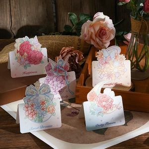Detailed view of floral 3D greeting cards with watercolor designs on vintage wooden table