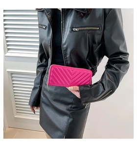 Détail du portefeuille long rose vif à surpiqûres chevron et zip doré sécurisé