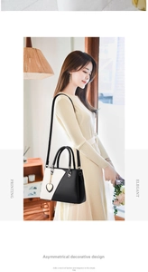 Elegant black and white contrast leather crossbody bag with chic gold heart pendant detail