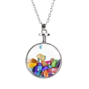 Detail of round glass pendant filled with colorful tumbled stones on a silver chain