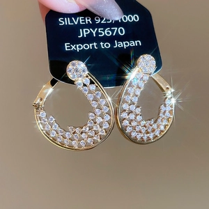 Détail de boucles d'oreilles goutte plaquées or 18K avec pavé de zircons sur carte
