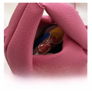 Detailed interior of the pink leather pleated bag showing storage capacity for cosmetics