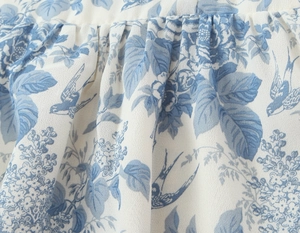 Detail of blue bird floral print on lightweight pleated chiffon dress fabric