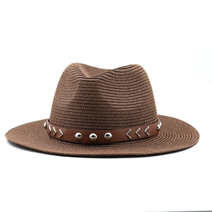 Close-up of brown straw fedora hat featuring a studded faux leather band and woven texture