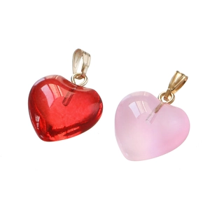 Detail view of heart-shaped acrylic pendants in red and pink with gold metal loops