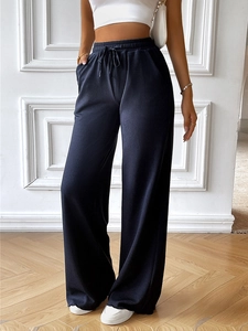 Detail of high waisted black wide leg trousers featuring a ribbed knit texture and pockets