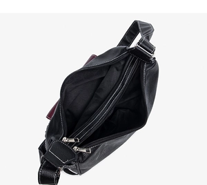 Close-up of black pebble leather tote interior with white stitching and silver zip