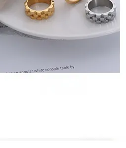 Detail of minimalist gold and silver gear-textured stainless steel rings on a ceramic plate